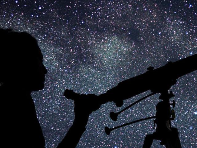 a person with a telescope looking at the stars in the night sky
