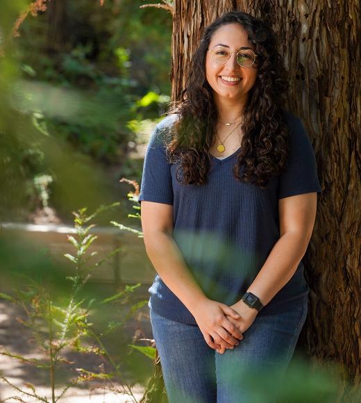 Photo portrait of Tatiana Muniz leaning against a redwood tree
