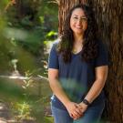 Photo portrait of Tatiana Muniz leaning against a redwood tree